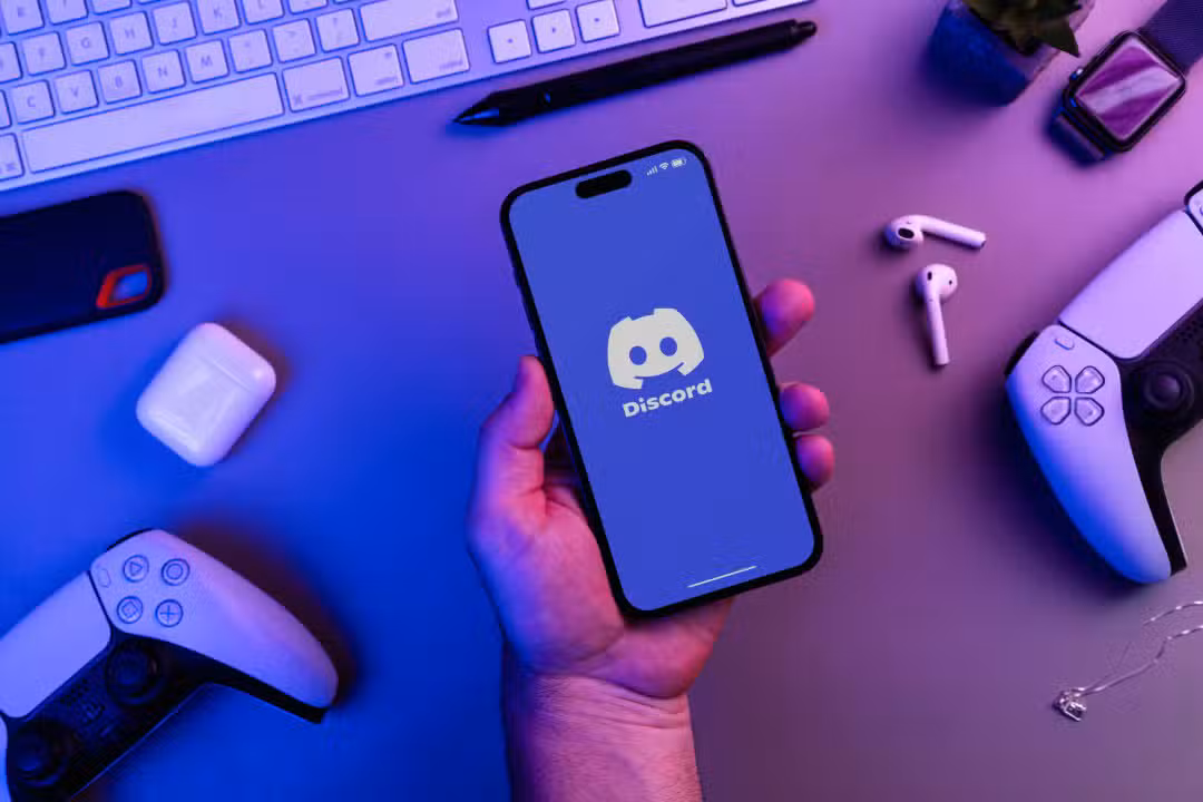 Man,Holding,An,Iphone,14,Pro,Smartphone,With,Discord,App