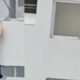 Mulher escorrega limpando janela