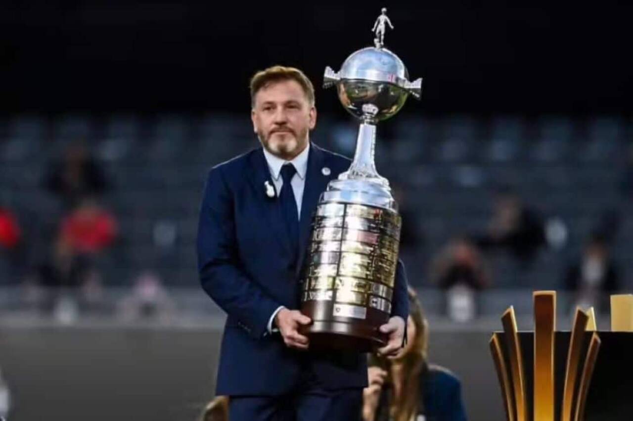 Alejandro Domínguez, presidente da Conmebol, carregando a taça da Libertadores