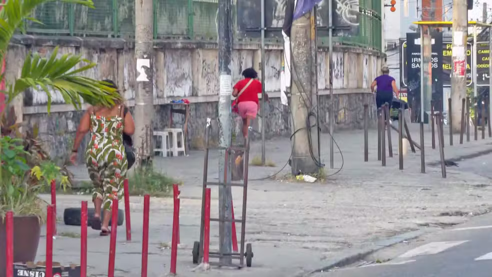 Pessoas correm na Avenida Itaoca, no Alemão, para fugir de tiros