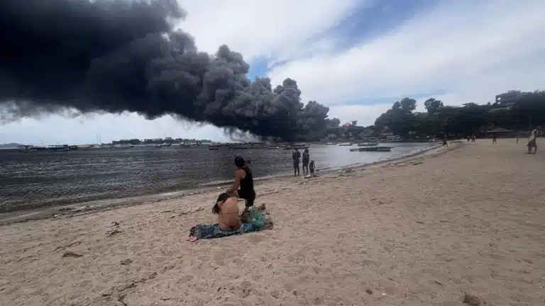 Banhistas observam fumaça de incêndio na Ilha do Governador