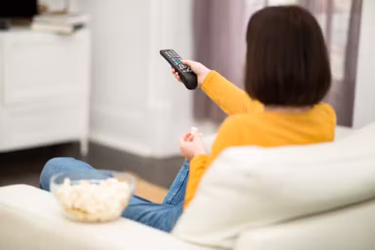 Mulher assistindo programação na tv