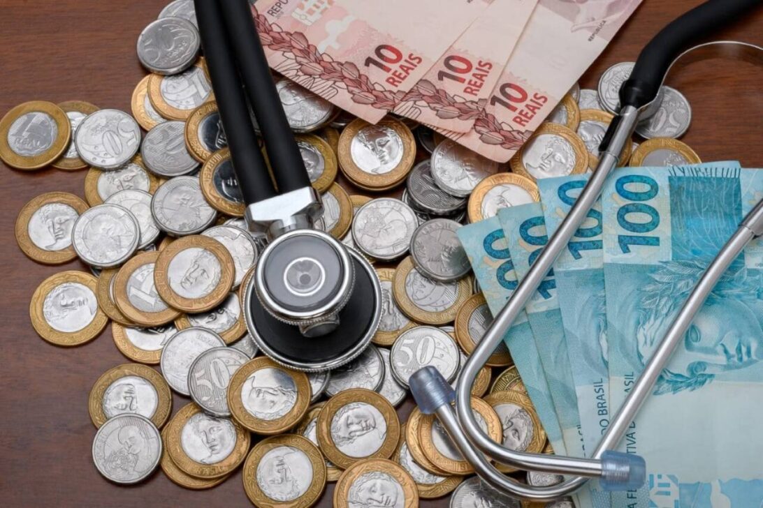 Estetoscópio em notas de real e moedas