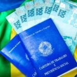 Carteira de Trabalho, cédulas de cem reais, salário mínimo