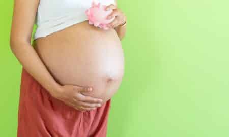 Mulher grávida segurando cofre conceito de salário-maternidade