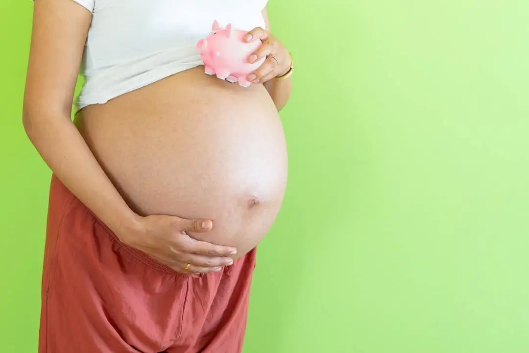 Mulher grávida segurando cofre conceito de salário-maternidade