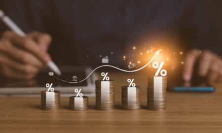 Pilha de moedas e símbolo de porcentagem invetsimentos