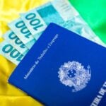 Carteira de Trabalho, cédulas de cem reais, salário mínimo