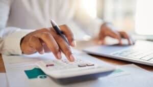 Empresário calculando finanças na mesa do escritório, calculadora