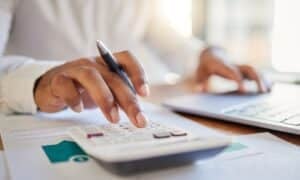 Empresário calculando finanças na mesa do escritório, calculadora