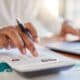 Empresário calculando finanças na mesa do escritório, calculadora