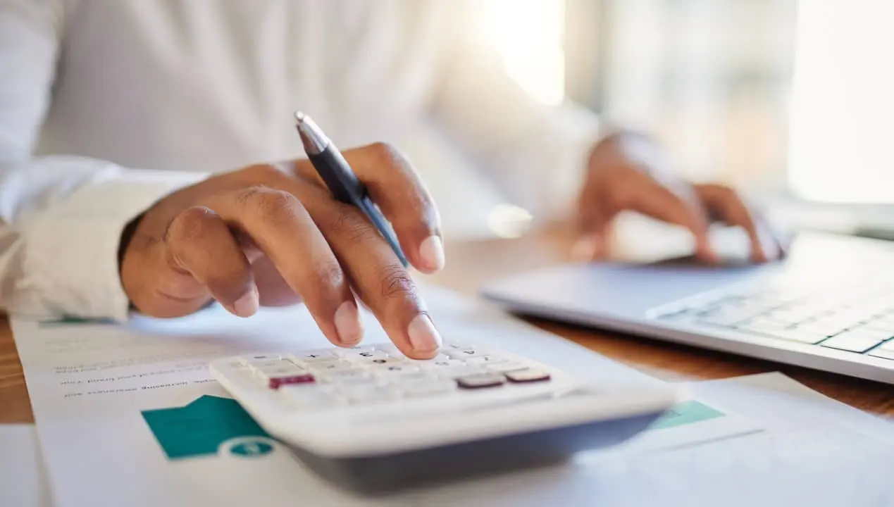 Empres&aacute;rio calculando finan&ccedil;as na mesa do escrit&oacute;rio, calculadora