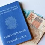Carteira de Trabalho, dinheiro, notas de 50 e 100 reais