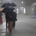 Chuva forte, pessoas com guarda-chuva