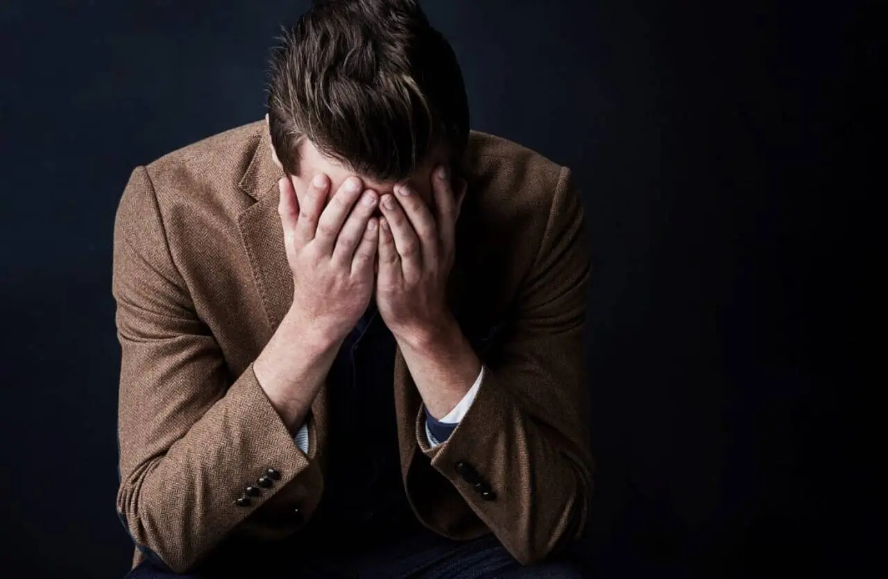 Homem com as mãos na cabeça, triste