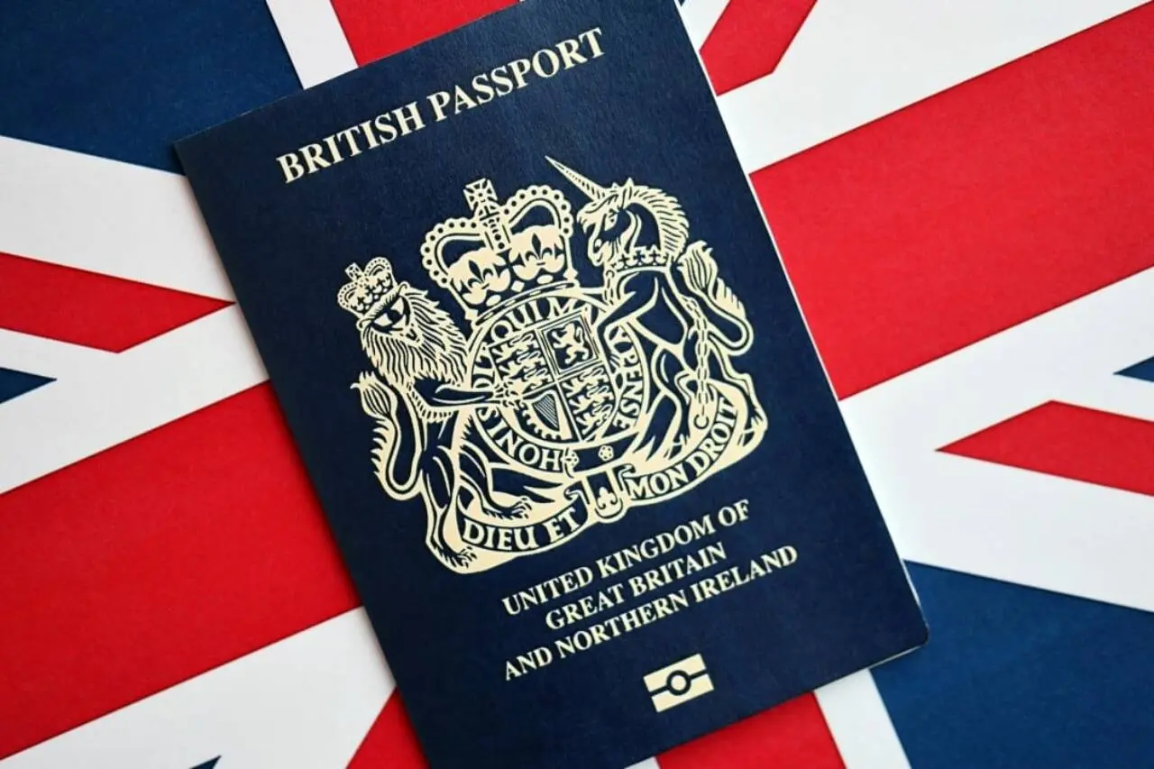 Passaporte britânico azul sobre fundo de bandeira
