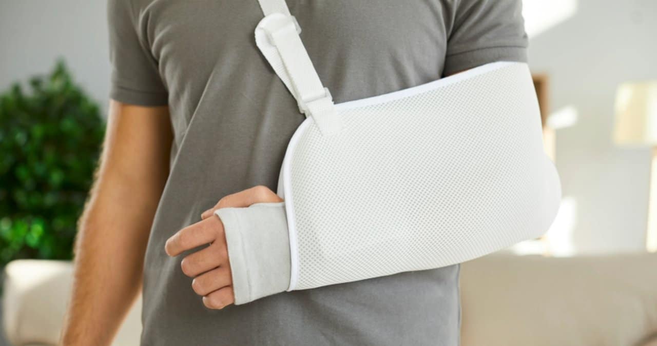 Homem com o braço machucado, auxílio acidente - Studio Romantic/ Shutterstock.com