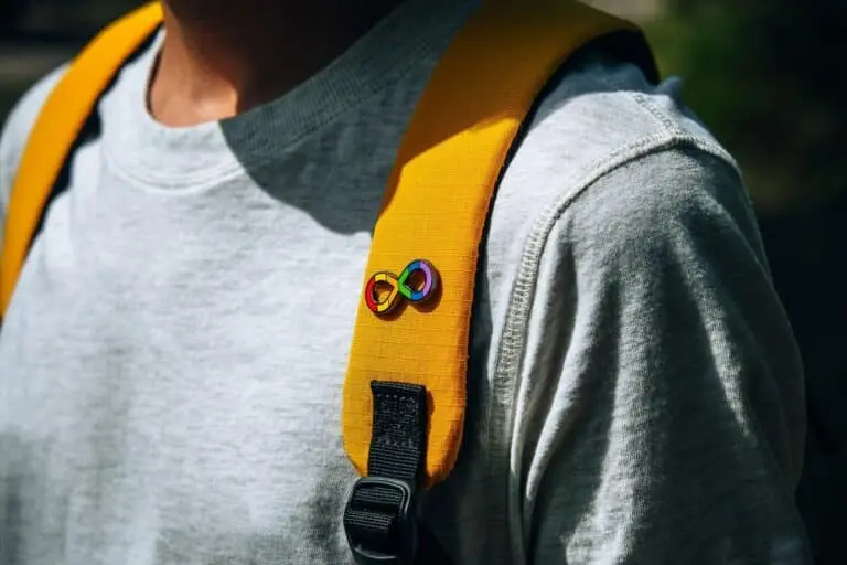 Garoto com mochila e símbolo de autismo
