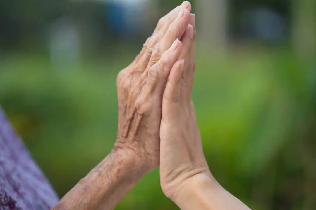 Mãos juntas, idosa e jovem