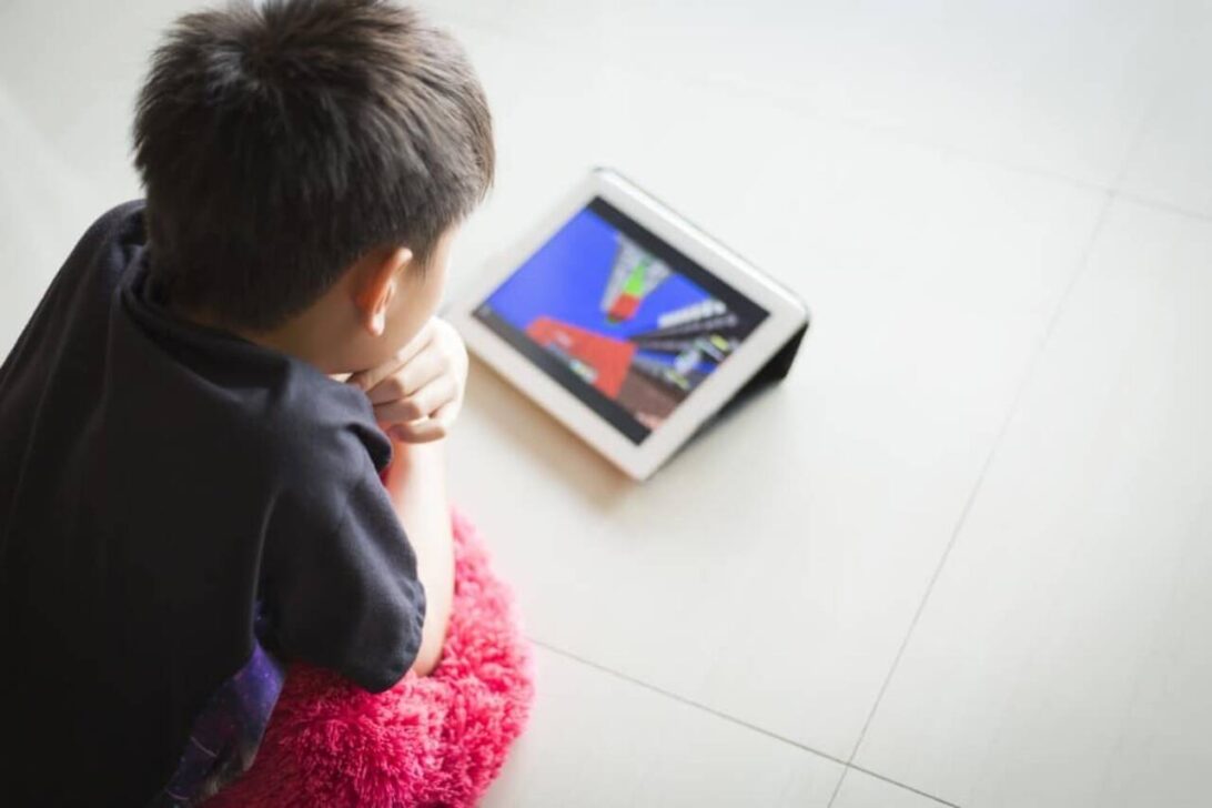 Criança assistindo vídeo em tablet
