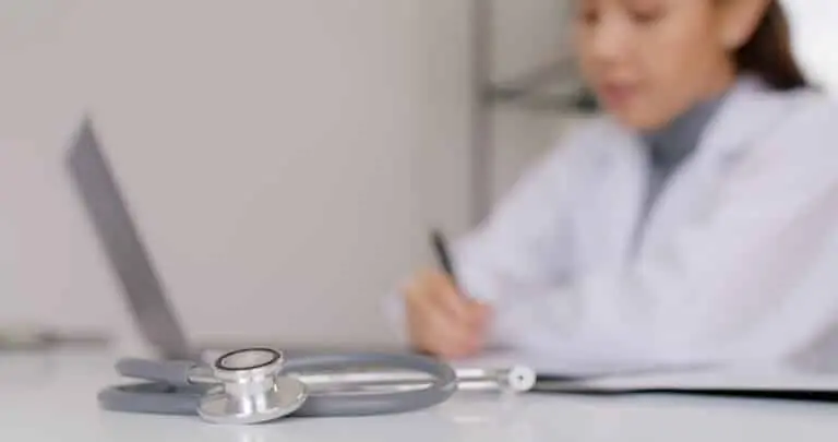 Estetoscópio, médica ao fundo