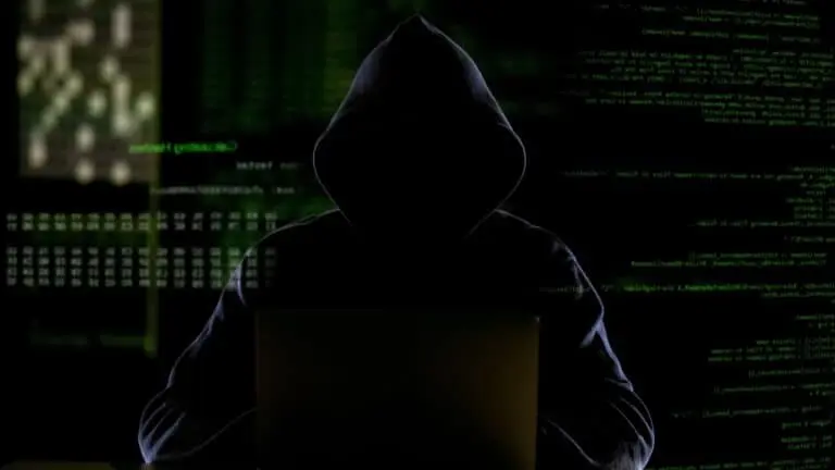 Homem encapuzado trabalhando com código de computador, hackeando software
