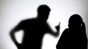 Silhueta homem e mulher, agressão, feminicídio.