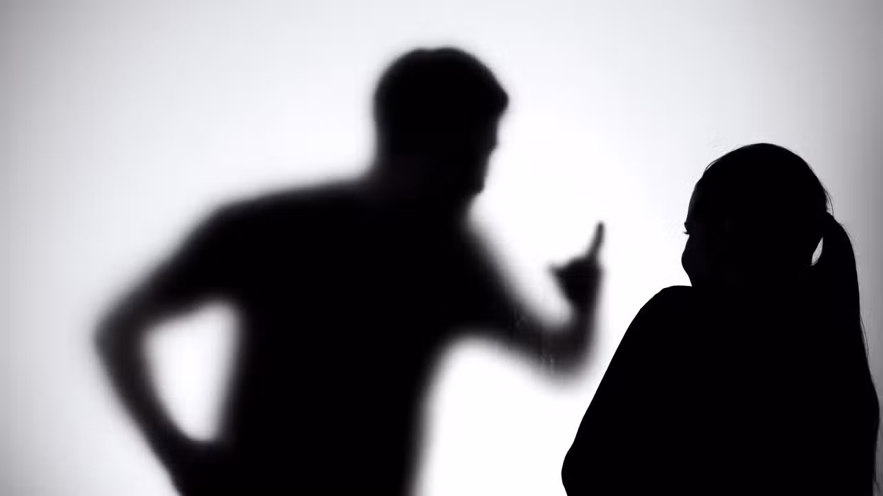 Silhueta homem e mulher, agressão, feminicídio.