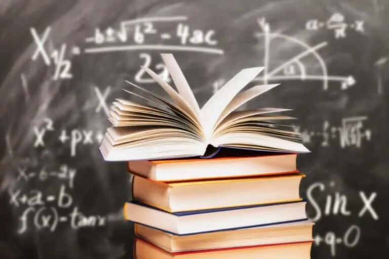 Pilha de livros na frente de um quadro-negro