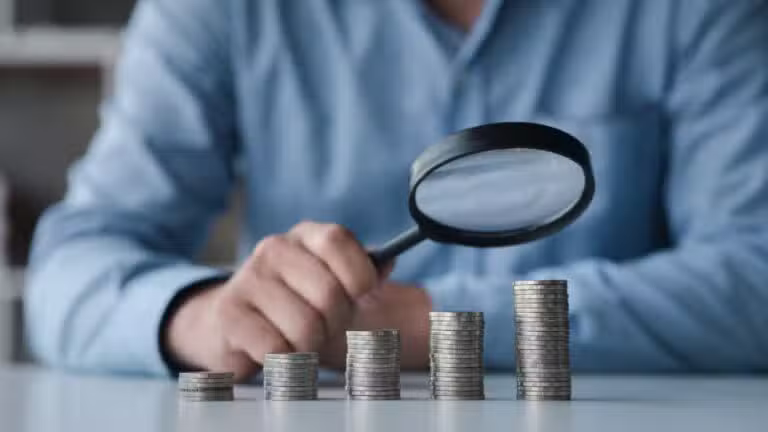Pilhas de moedas, lupa, conceito de finanças