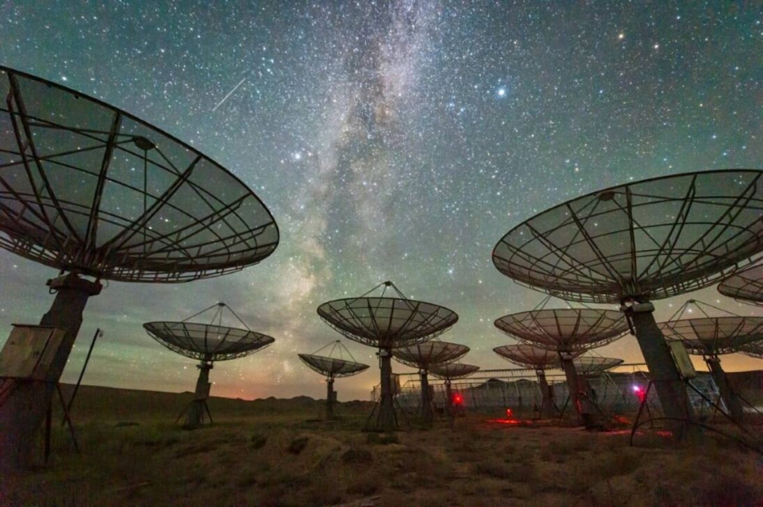 Conjunto de antenas de satélite sob o céu da Via Láctea