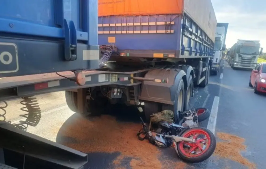 Motociclista tenta passar em 'corredor' de congestionamento, mas acaba embaixo de carreta