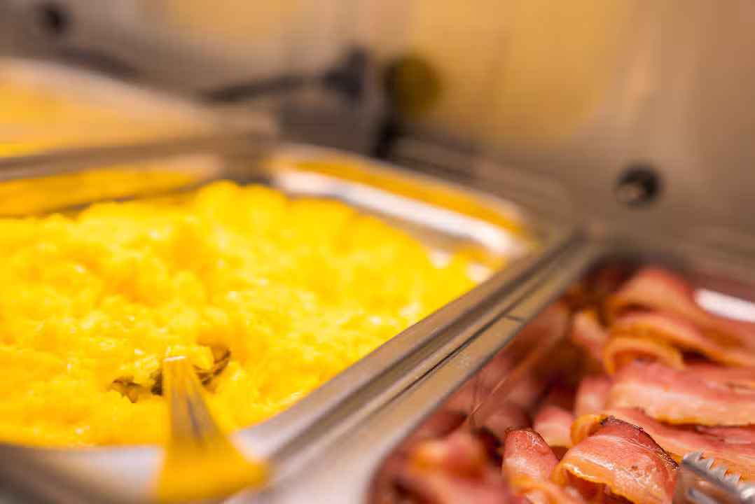ovos mexidos e bacon em bandeja, buffet