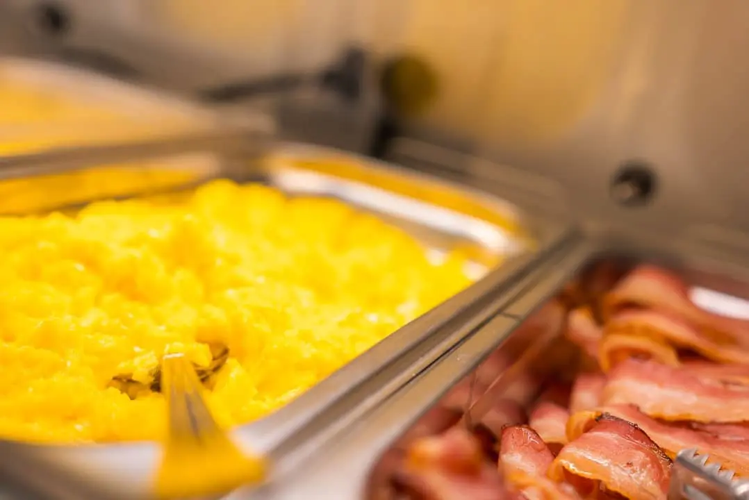 ovos mexidos e bacon em bandeja, buffet
