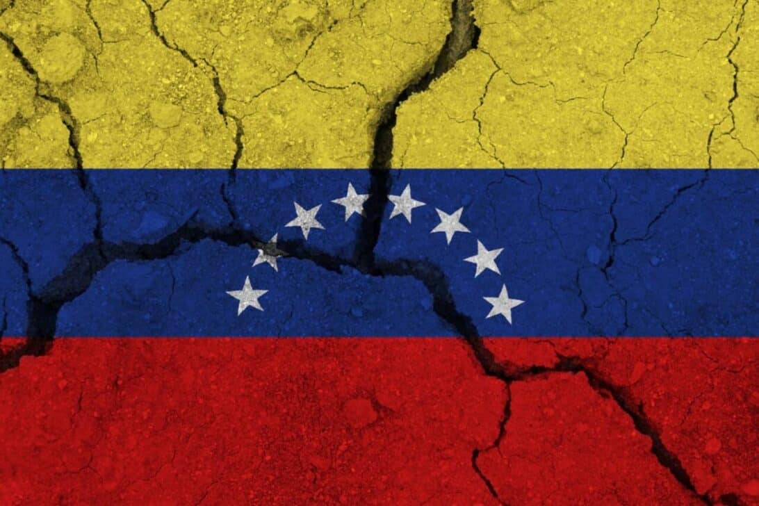 Bandeira de Venezuela na terra rachada, conceito de terremoto