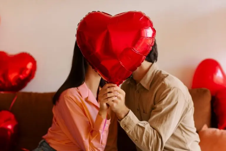 Casal beijando e segurando balão de coração, Dia dos Namorados