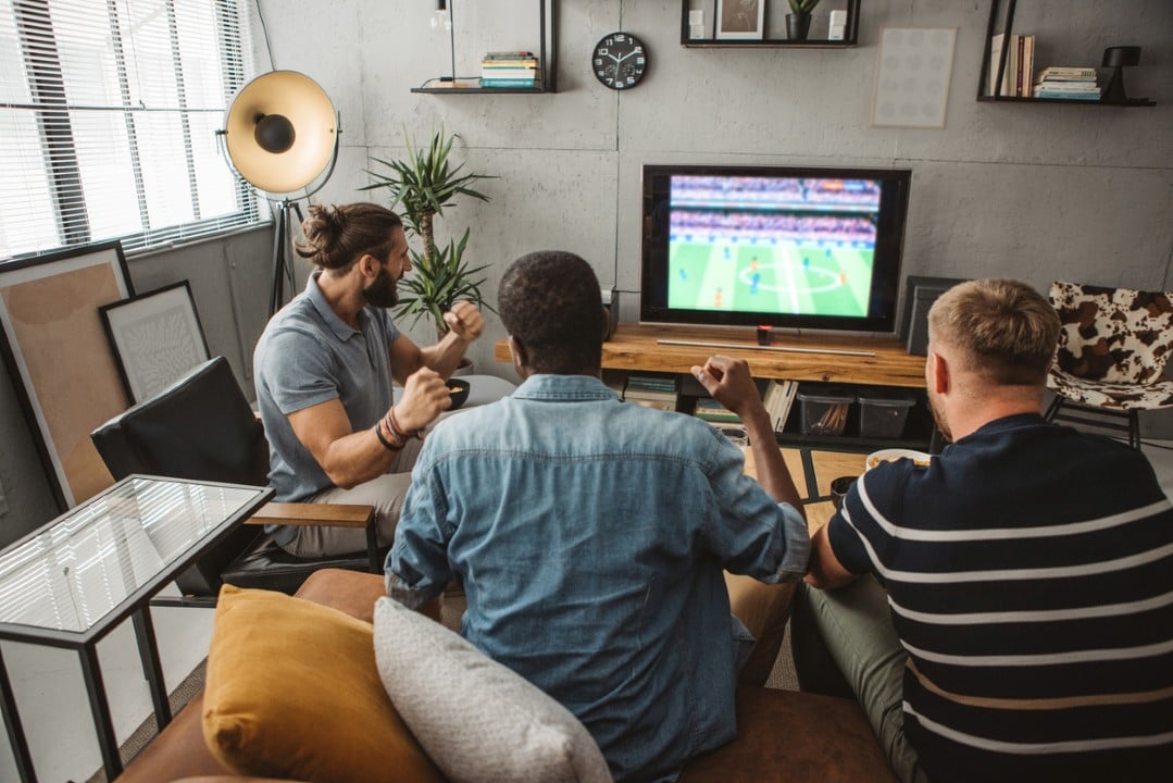 Homens assistindo jogo de futebol, TV