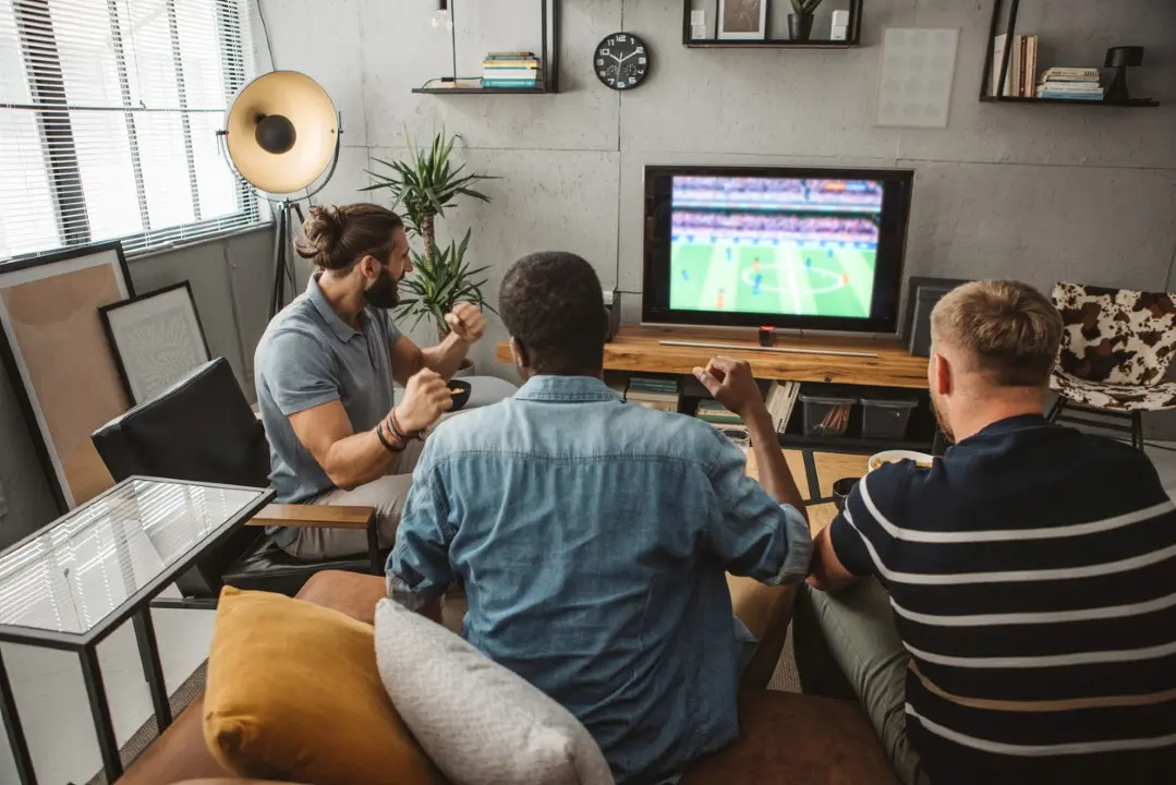 Homens assistindo jogo de futebol, TV