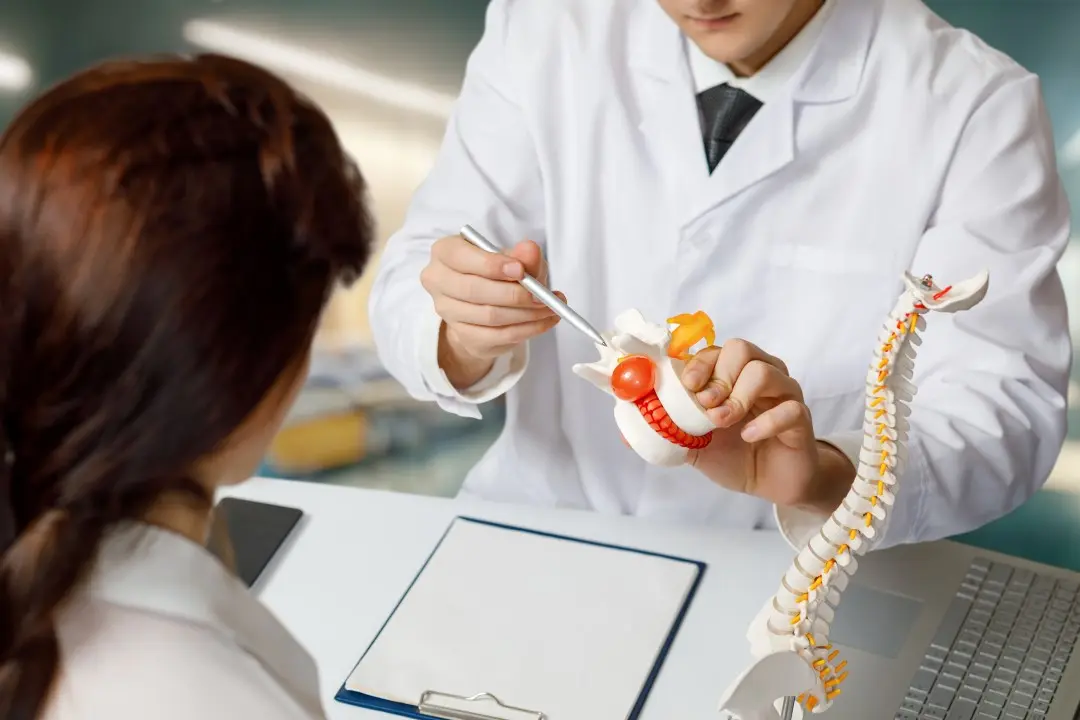 Médico mostrando vertebra com hérnia de disco