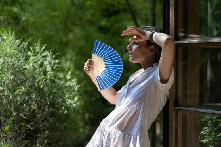 Mulher com leque se abanando, calor, verão