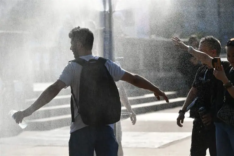 Pessoas se refrescando na fonte, calor