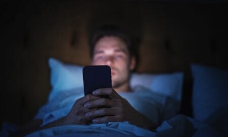 Uso de tela, celular, homem na cama usando telefone