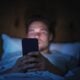 Uso de tela, celular, homem na cama usando telefone