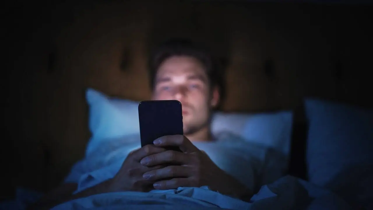 Uso de tela, celular, homem na cama usando telefone