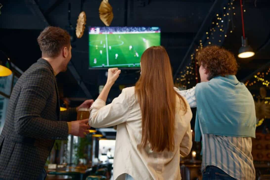 pessoas assintindo partida de futebol