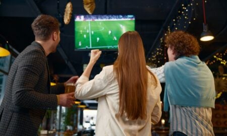 pessoas assintindo partida de futebol