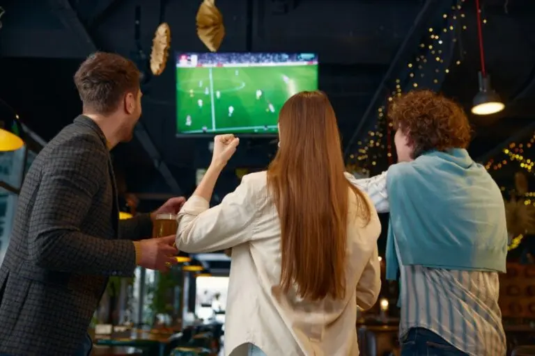 pessoas assintindo partida de futebol