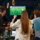 pessoas assintindo partida de futebol