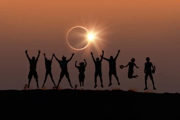 Amigos pulando observando eclipse solar total