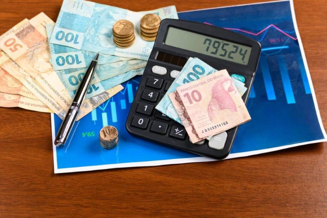Dinheiro, cédulas de 10, 50 e 100 reais, moeda real, calculadora, gráfico financeiro